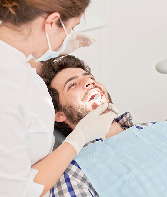 A man receiving dental care from a dentist in an office setting.